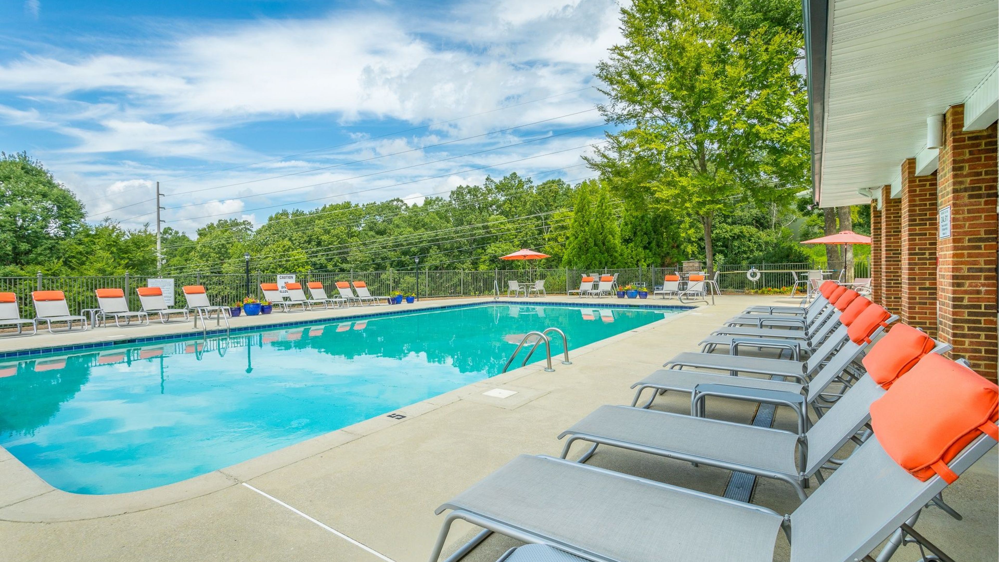 Hawthorne at the Ridge large outdoor pool with lounge chairs, surrounded by green trees