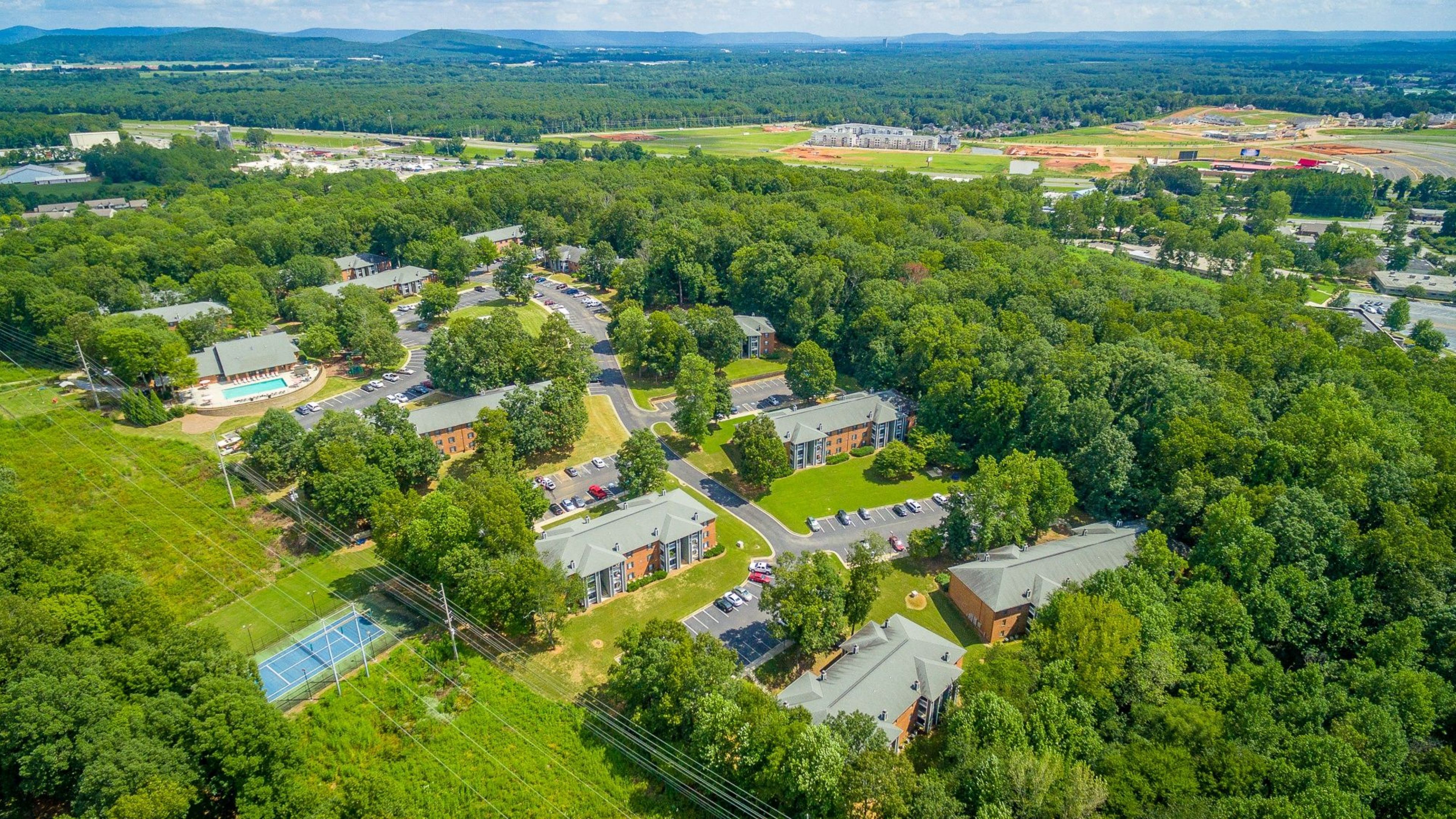 Hawthorne at the Ridge aerial view of community including apartment buildings, pool, tennis court, and parking, look towards Madison, Alabama